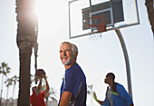 Older men playing basketball on court