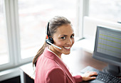 Businesswoman wearing headset at desk