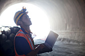 Worker using laptop in tunnel