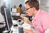 Businessman eating Chinese food at desk