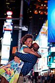 Couple hugging on city street at night