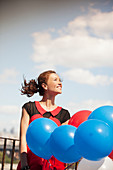 Woman carrying bunch of balloons