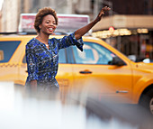 Woman hailing taxi on city street