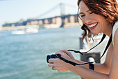 Woman taking picture by urban bridge