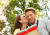Woman kissing boyfriend in park