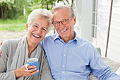 Smiling couple sitting on porch swing