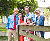 Family smiling together by wooden fence