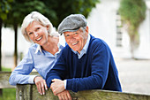 Couple smiling by wooden fence