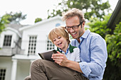 Father and son using digital tablet