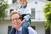 Father carrying son on shoulders outdoors