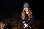 Girl playing with sparkler outdoors