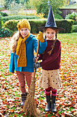 Girls playing with witch's hat and broom