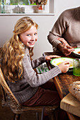 Smiling girl eating at table