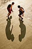 Men playing basketball on court