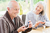 Older couple testing blood sugar together