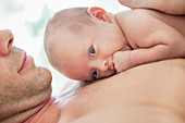 Father cradling newborn baby on chest