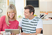 Couple using tablet computer at table