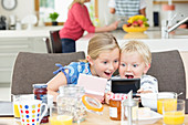 Children playing video games at breakfast
