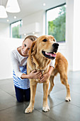 Girl hugging dog indoors