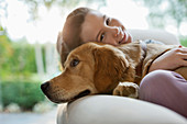 Girl relaxing with dog on sofa