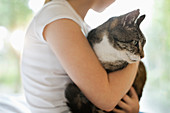 Girl holding cat indoors