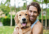 Smiling man petting dog outdoors