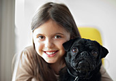 Smiling girl holding dog