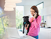 Woman on cell phone holding dog