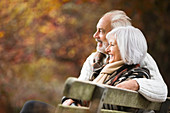 Older couple sitting on park bench