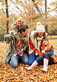 Family playing together in autumn leaves