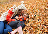 Mother and daughter in autumn leaves