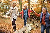 Family walking on log in park
