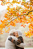 Older couple hugging in park