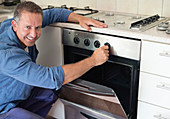 Electrician working on oven in kitchen