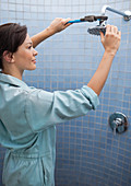 Female plumber working on shower head