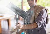 Man washing window with squeegee