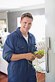 Electrician working on telephone in home