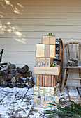 Stack of Christmas gifts on snowy patio