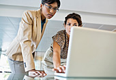 Businesswomen using laptop together