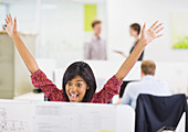 Businesswoman cheering at desk