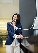 Businesswoman talking on pay phone