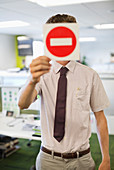 Businessman holding warning sign