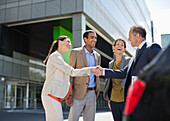 Business people shaking hands outdoors