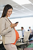 Pregnant businesswoman using cell phone