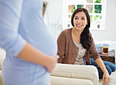 Woman smiling at pregnant friend