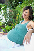Pregnant woman relaxing outdoors