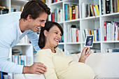 Pregnant woman showing boyfriend sonogram