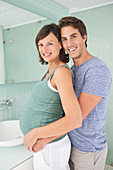 Smiling couple hugging in bathroom