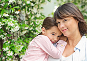 Mother carrying daughter outdoors