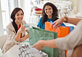 Woman showing friends shopping bags